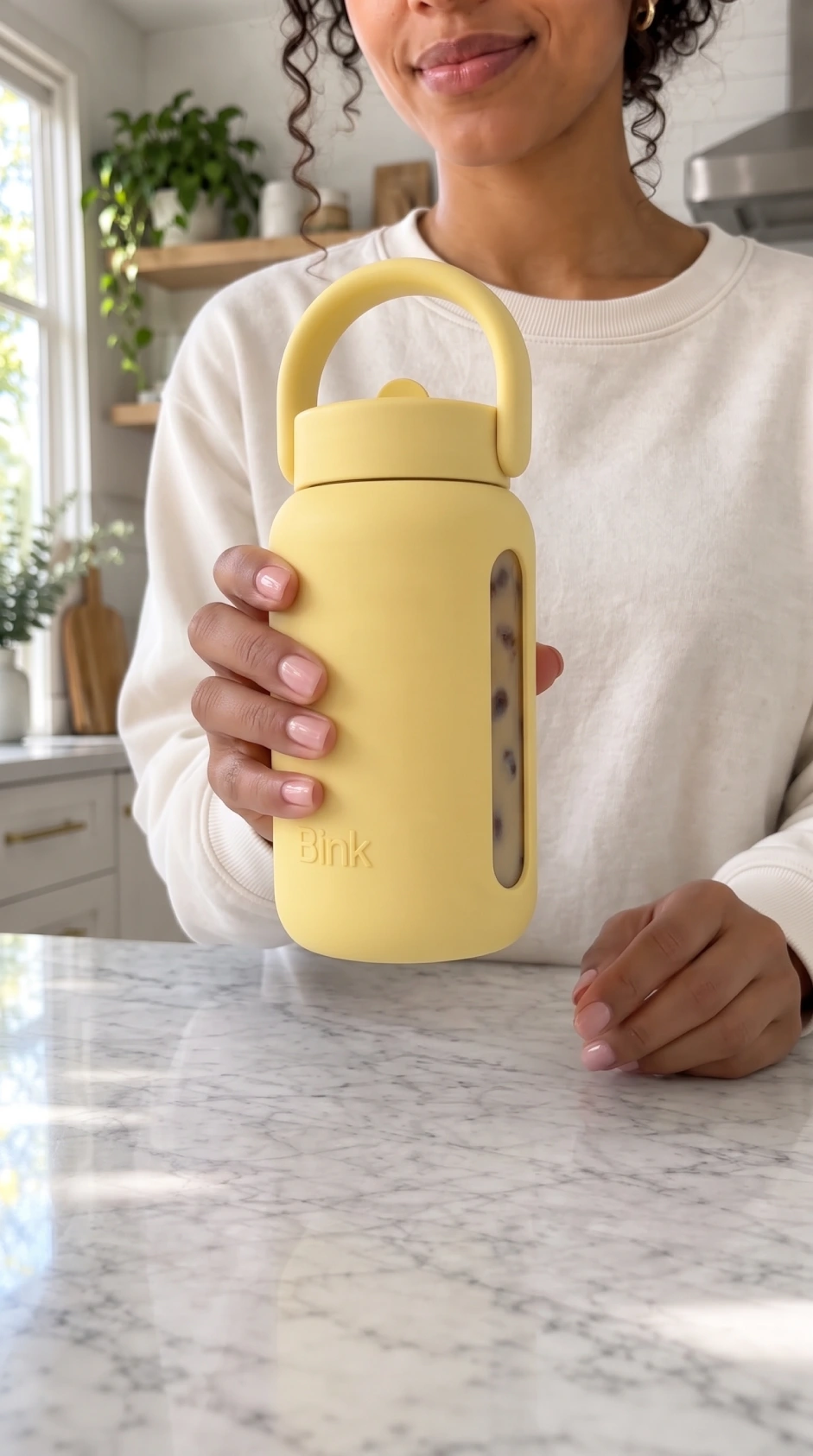 Reference image of the model holding the bottle up in the air
